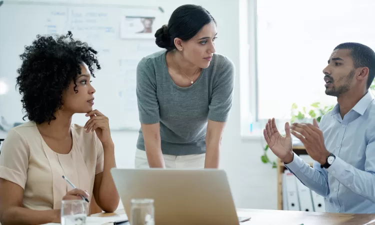 Three people having a discussion in a professional environment